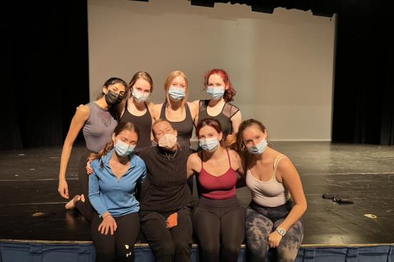 Kristen Daley and dancers sitting on stage with masks on