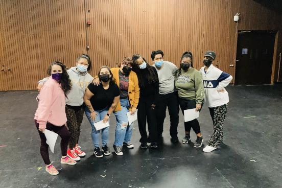 Group of students posing together with some holding paper in their hands