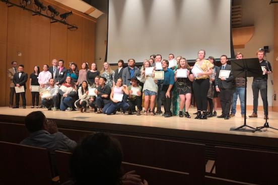 Students on Stage Receiving Scholarship Certificates