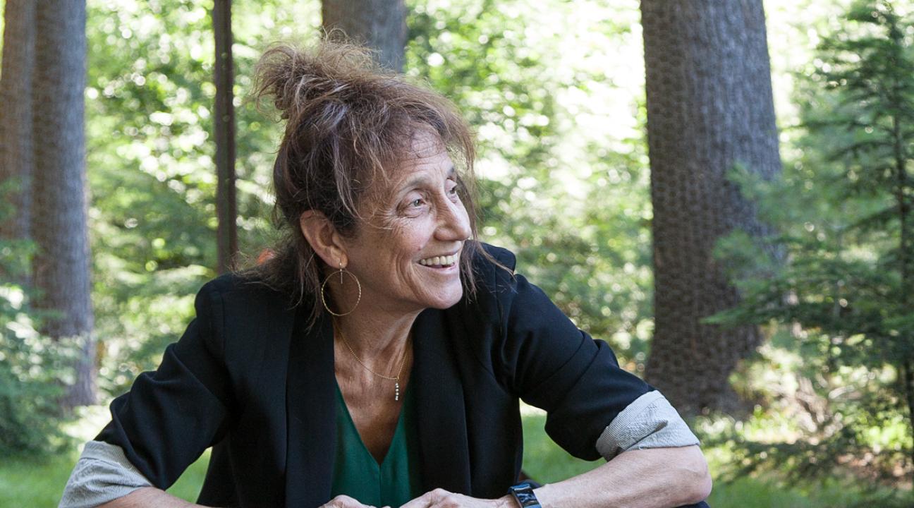 Liz Lerman Headshot sitting and looking to the right