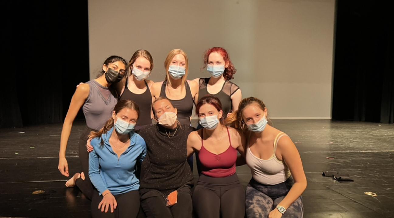 Kristen Daley and dancers sitting on stage with masks on