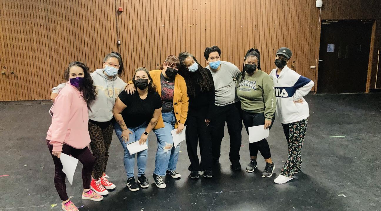 Group of students posing together with some holding paper in their hands