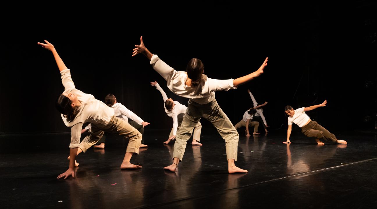 Dancers leaning backward on stage in exaggerated positions