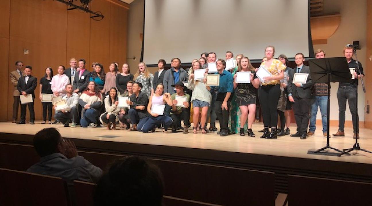 Students on Stage Receiving Scholarship Certificates