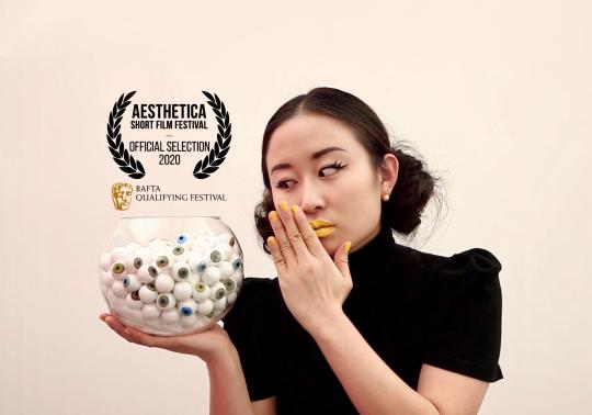 movie poster with woman holding bowl of fake eyeballs