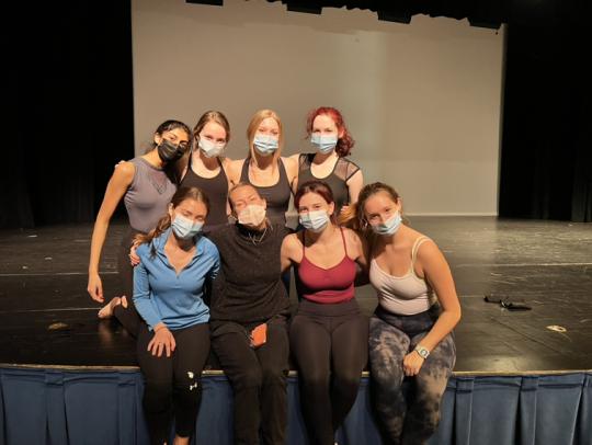 Kristen Daley and dancers sitting on stage with masks on