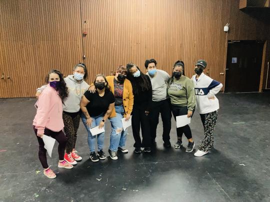 Group of students posing together with some holding paper in their hands