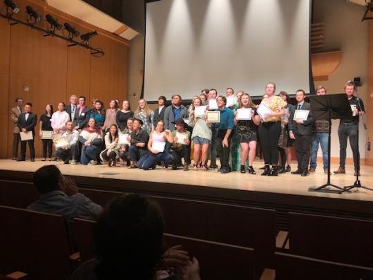 Students on Stage Receiving Scholarship Certificates