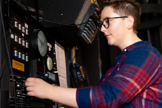 Student adjusts switch at control panel